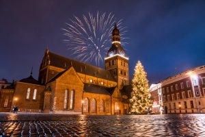 A low angle shot of the colorful fireworks on the church on a starry evening